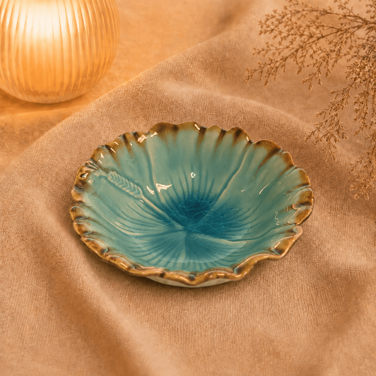 Blauwe bloemschaal van 15 cm met golvende bruine rand en bloemvormig reliëf, sfeervol gepresenteerd.