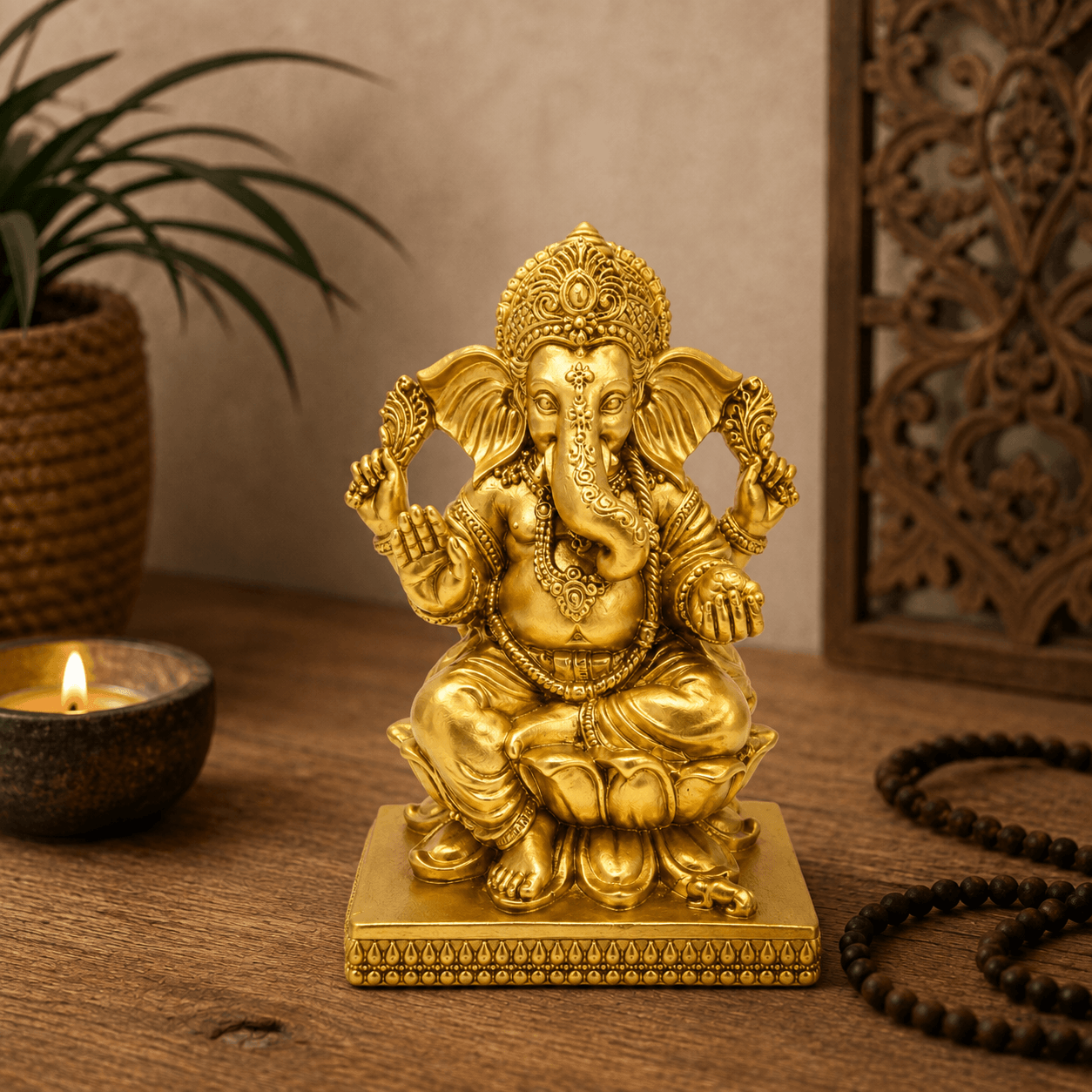 Goudkleurig Ganesha beeld Lotus op een houten tafel met kaars, kamerplant en warme sfeerverlichting.