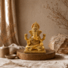 Ganesha beeld Maharaja in champagne en goud op een houten plateau in een warm natuurlijk interieur met linnen en aardetinten