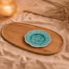 Blauw bloembordje van 13,5 cm, sfeervol gepresenteerd op een houten schaal met beige textiel en warme verlichting.
