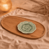 Groen bloembordje van 13,5 cm, sfeervol gepresenteerd op een houten schaal met beige textiel en warme verlichting.
