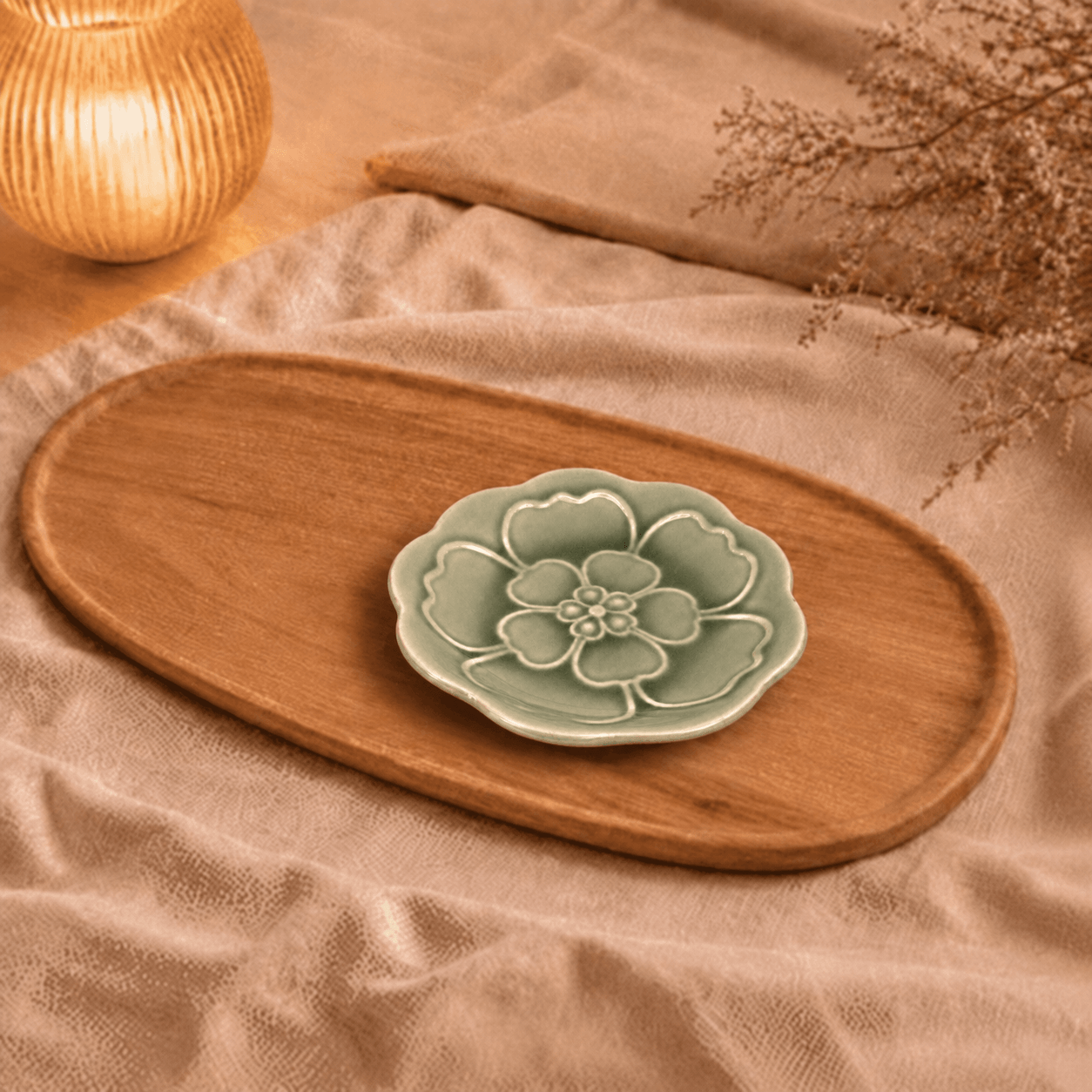 Groen bloembordje van 13,5 cm, sfeervol gepresenteerd op een houten schaal met beige textiel en warme verlichting.