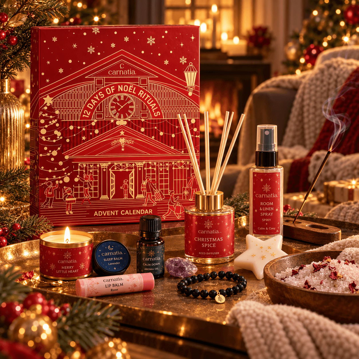 Carnatia 12 Days of Noël Rituals adventskalender met geurstokjes, geurkaars, roomspray, aromaolie en wellnessaccessoires in een warme kerstsetting met lichtjes en dennentakken.